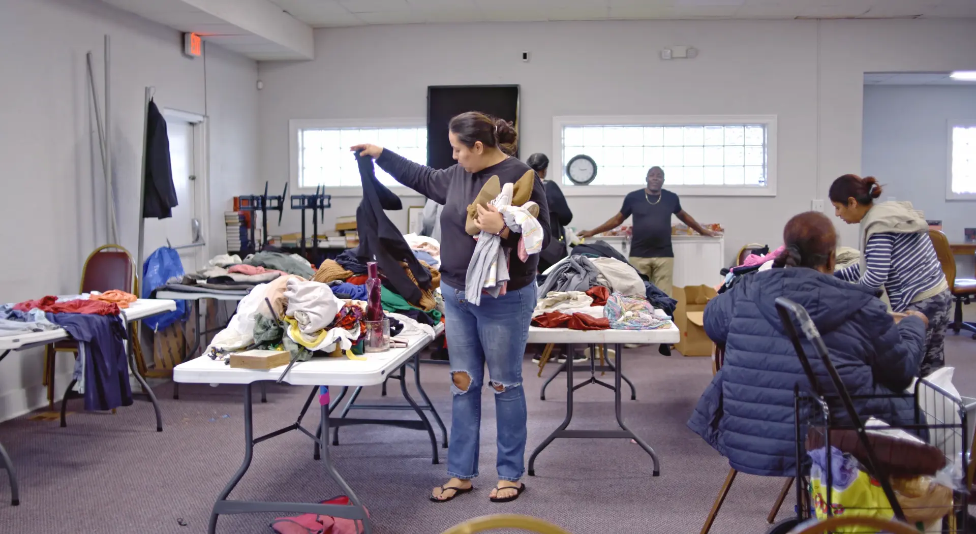 A mother choosing clothing at an AIM clothing and resource distribution