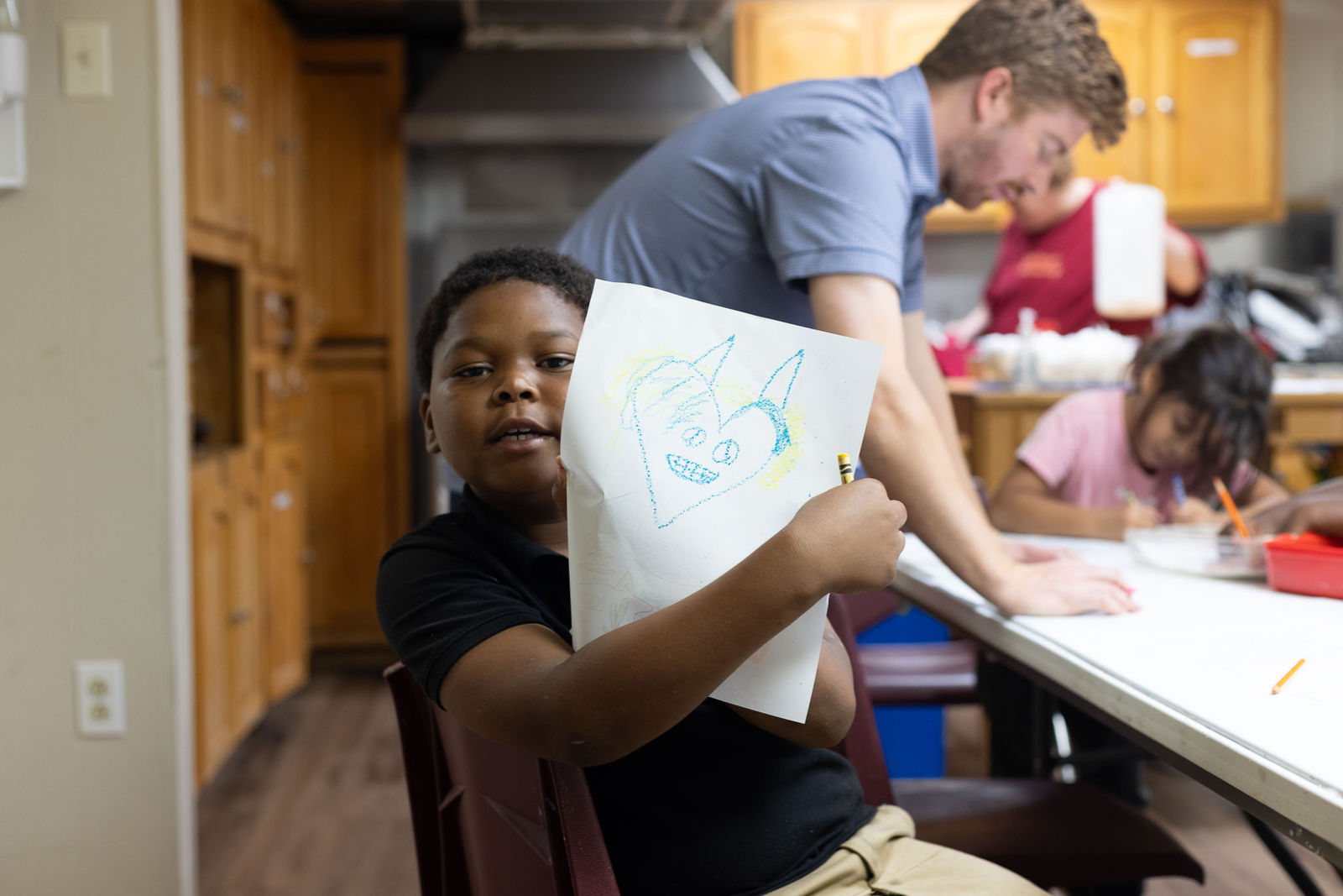 Kids working on crafts at an AIM program table