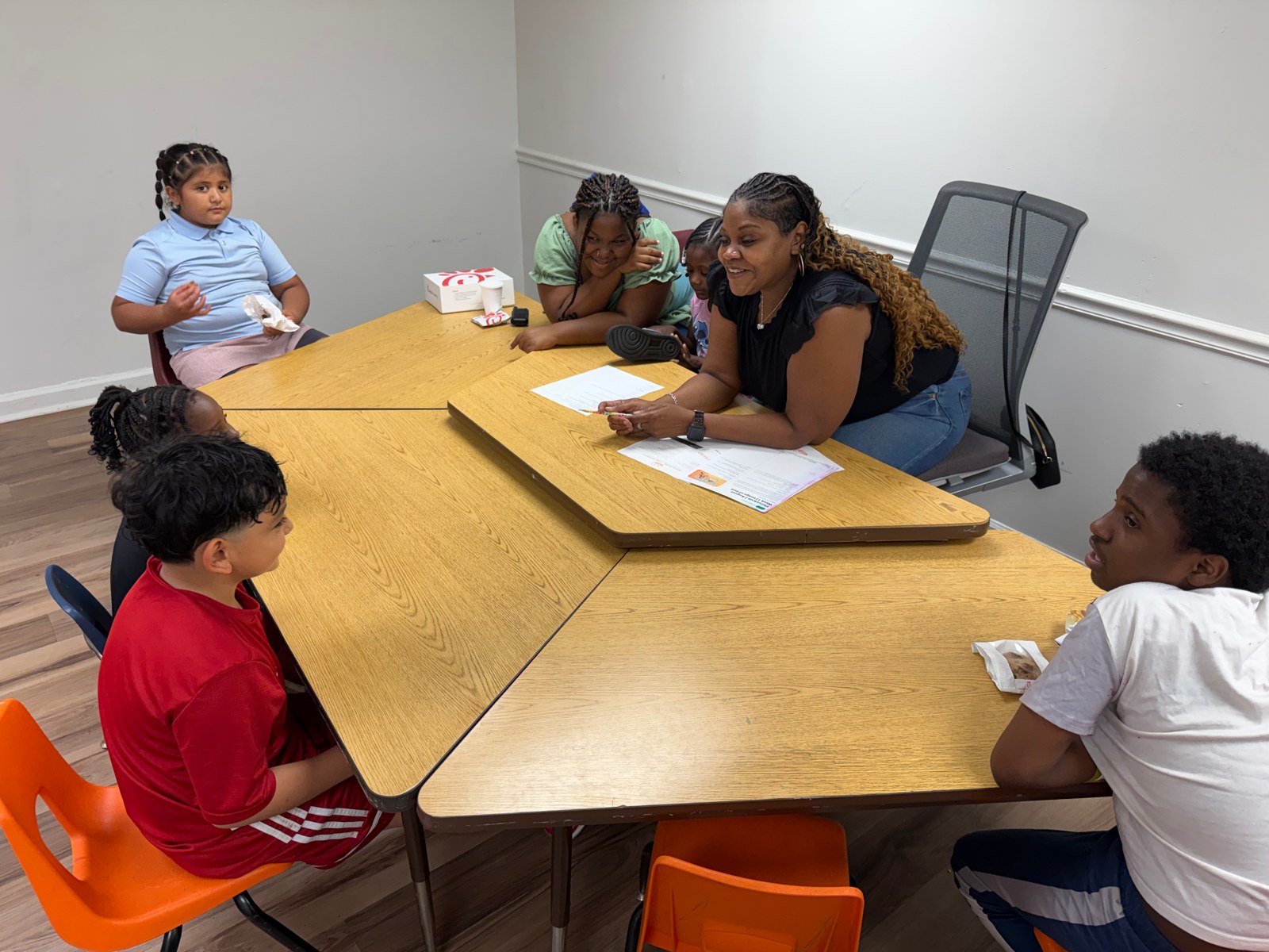 Elementary students coloring and laughing with volunteers at ThriveKids